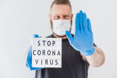Coronavirus kavramını durdur. Coronavirus 'u durdurun. Koronavirüs COVID-19 salgını sırasında lateks eldiven takan ve koruyucu maske takan adamın ellerinde. Sağlık ve güvenlik.