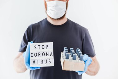 El hijyen önleyici alkol jeli şişeleri ve ışık kutusu. Coronavirus 'u durdurun. Koronavirüs COVID 19 salgını sırasında lateks eldiven ve koruyucu maske takan adamın ellerinde. Sağlık Hizmetleri