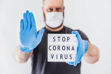 Coronavirus kavramını durdur. Coronavirus 'u durdurun. Koronavirüs COVID-19 salgını sırasında lateks eldiven takan ve koruyucu maske takan adamın ellerinde. Sağlık ve güvenlik.