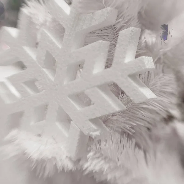 Белое рождественское украшение со снежинкой на еловых ветвях — стоковое фото