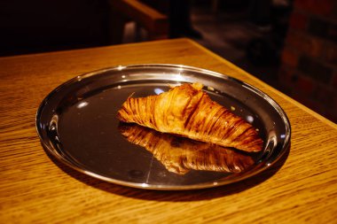 Yansıtıcı plaka üzerinde lezzetli kruvasan 