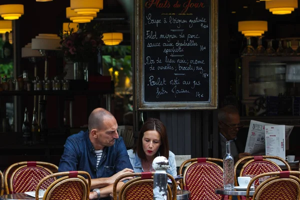 Parisiens et touristes dégustent de la nourriture et des boissons sur le trottoir du café à Paris — Photo