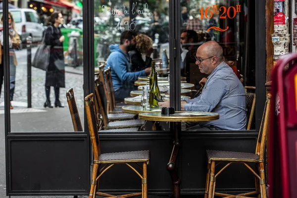 Pariser und Touristen genießen Essen und Getränke auf dem Bürgersteig eines Cafés in Paris — Stockfoto