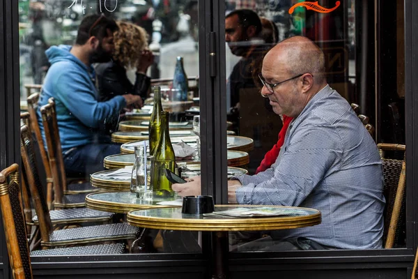 Parisienses e turistas desfrutam de comida e bebidas na calçada do café em Paris — Fotografia de Stock