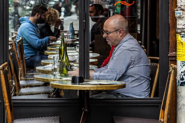 Parisienses e turistas desfrutam de comida e bebidas na calçada do café em Paris — Fotografia de Stock