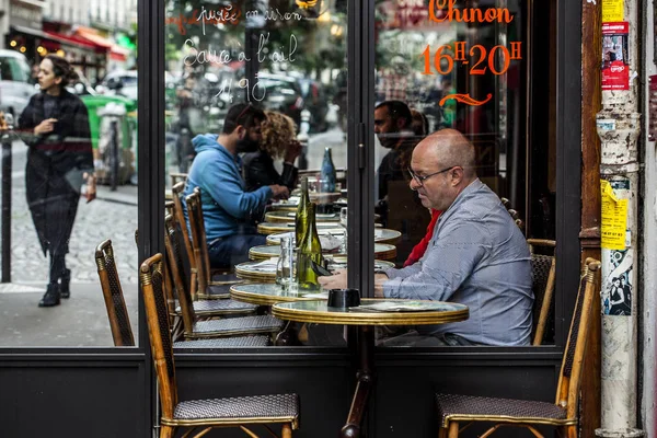 Parisians and tourists enjoy food and drinks in cafe sidewalk in Paris — Stock Photo, Image