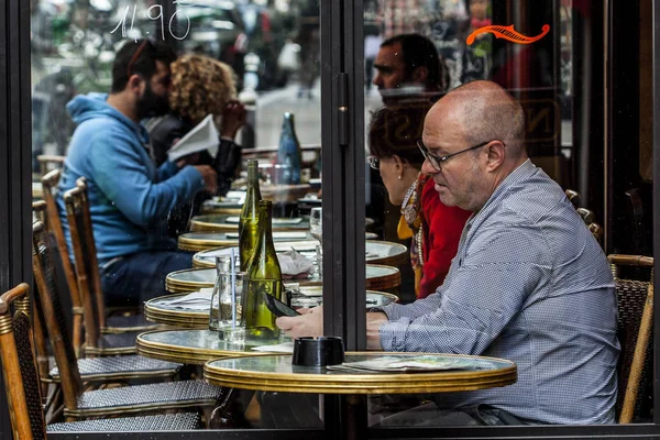 Parisienses e turistas desfrutam de comida e bebidas na calçada do café em Paris — Fotografia de Stock