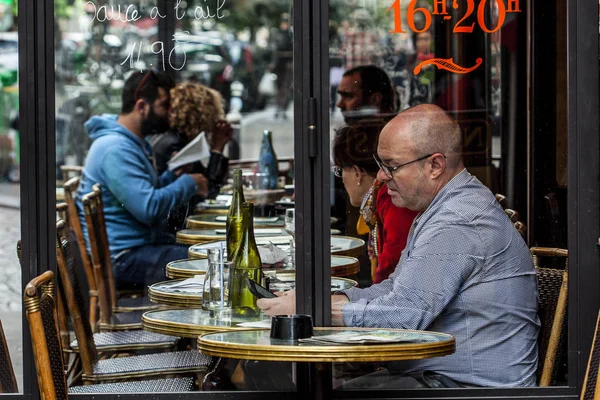 Parisiens et touristes dégustent de la nourriture et des boissons sur le trottoir du café à Paris — Photo