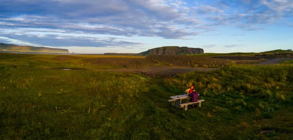 Twee vrouwen toeristen zitten aan de tafel in IJsland op zonsondergang tim — Stockfoto