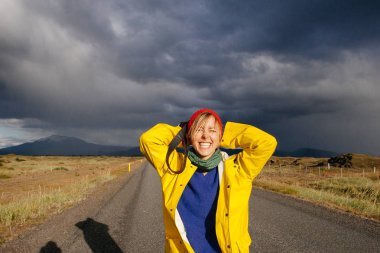Mutlu turist kadın parlak giysiler ve sarı ceket, zevk