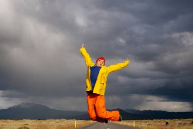 Mutlu turist kadın parlak giysiler ve sarı ceket, zevk