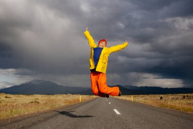 Mutlu turist kadın parlak giysiler ve sarı ceket, zevk