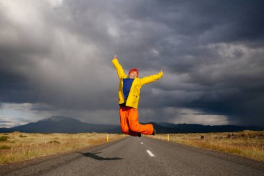 Mutlu turist kadın parlak giysiler ve sarı ceket, zevk