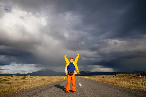 Glückliche Touristin in heller Kleidung und gelbem Mantel und genießt — Stockfoto
