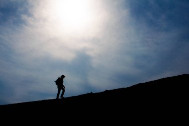 Üstünde belgili tanımlık tepe, yürüyen turist siluet