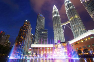 Kuala Lumpur, Malezya. 26 Ocak 2020: Petronas İkiz Kuleleri ve Malezya 'nın en çekici yeri olan Senfoni Gölü' nün gece manzarası. Güzel çok renkli müzik çeşmeleri.