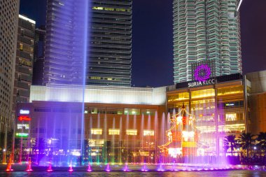 Kuala Lumpur, Malezya. 26 Ocak 2020: Petronas İkiz Kuleleri ve Malezya 'nın en çekici yeri olan Senfoni Gölü' nün gece manzarası. Güzel çok renkli müzik çeşmeleri.