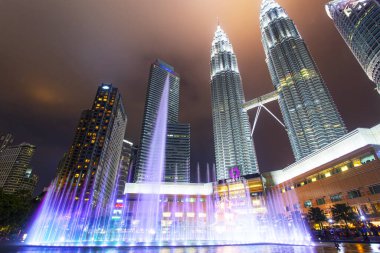 Kuala Lumpur, Malezya. 26 Ocak 2020: Petronas İkiz Kuleleri ve Malezya 'nın en çekici yeri olan Senfoni Gölü' nün gece manzarası. Güzel çok renkli müzik çeşmeleri.