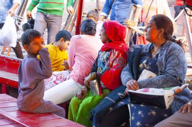 RISHIKESH, INDIA, 1 Aralık 2019: Seyyahlar Hindistan 'ın Uttarakhand eyaletindeki Rishikesh ruhani kasabasında Ganga Nehri' ni geçmek için bir tekneye binerler.
