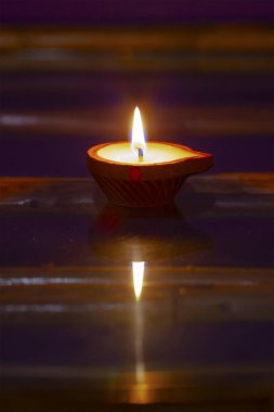 Camdaki kil şamdandaki mum, yansıtan alev.