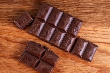 Tahta arka planda gözenekli sütlü çikolata.