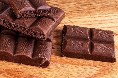 Tahta arka planda gözenekli sütlü çikolata.