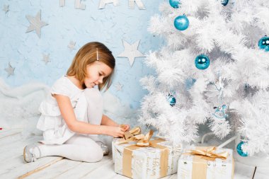 küçük kız şerit bir Noel hediyesi bağcıklı.