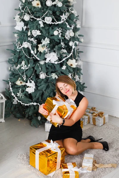 Joven hermosa mujer sonriendo felizmente. En las manos de un regalo de Navidad . — Foto de Stock