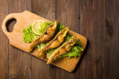 Ahşap rustik boyutunda bir tahta üzerinde çıtır çıtır kızarmış balık