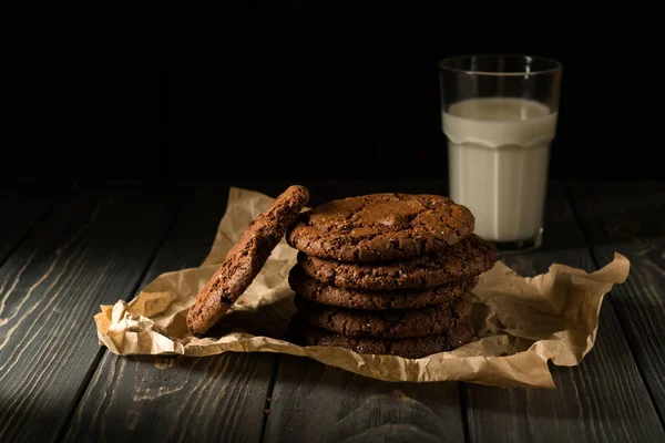 Schokoladenkekse auf Bastelpapier mit Glas Milch — Stockfoto