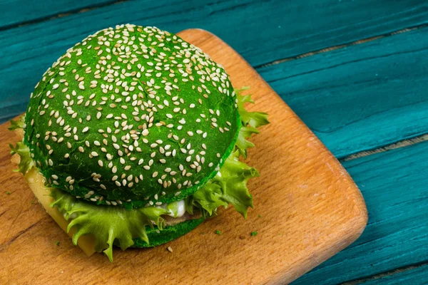 Hamburguesa verde fresca sobre fondo verde — Foto de Stock