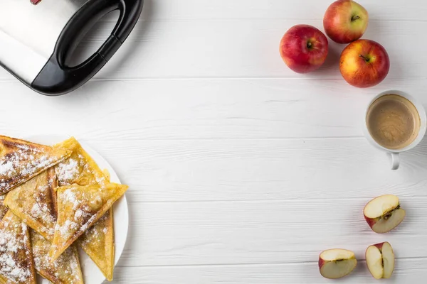 Pies lie on the table next to apples, a toaster and a cup of coffee — Stock Photo, Image