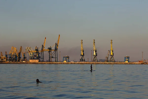 MARIUPOL, UCRANIA - 5 DE SEPTIEMBRE DE 2016: Muchas grúas grandes silueta en el puerto a la luz dorada de la puesta del sol. Mariupol, Ucrania — Foto de Stock
