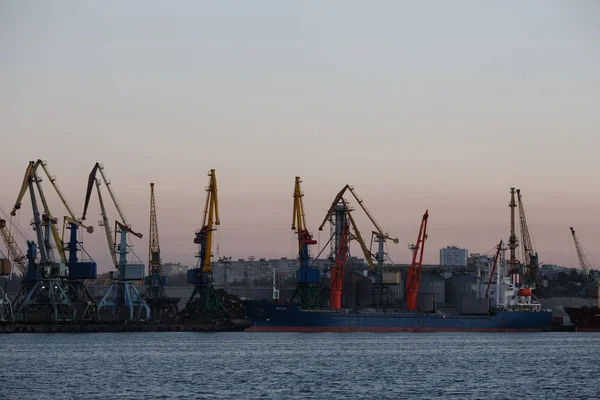 BERDIANSK - UCRANIA, 02 DE SEPTIEMBRE DE 2016: Muchas grúas grandes silueta en el puerto marítimo — Foto de Stock