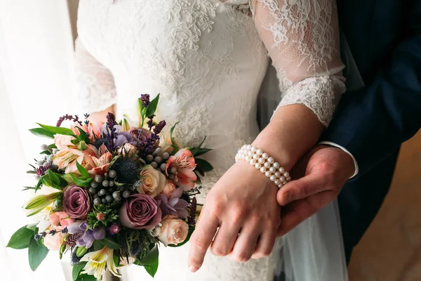 Detail of bride's bouquet and hands holding — Stock Photo, Image