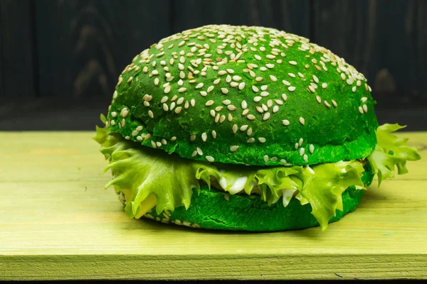 Färska välsmakande hamburgare på grön bakgrund — Stockfoto