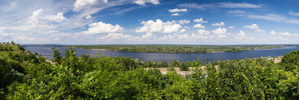 Panoramic view from mountain Tarasova in Kanev, Cherkassy region, on small island and hydroelectric dam on broad Dnieper in quiet evening summertime sunset