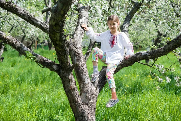 Cute girl dressed in embroidery in the garden — Stock Photo, Image