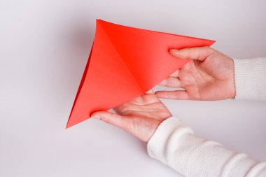 Origami kalp üzerine beyaz yakın yapma eller