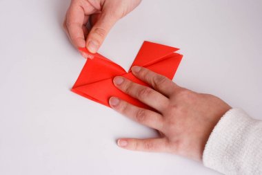 Origami kalp üzerine beyaz yakın yapma eller