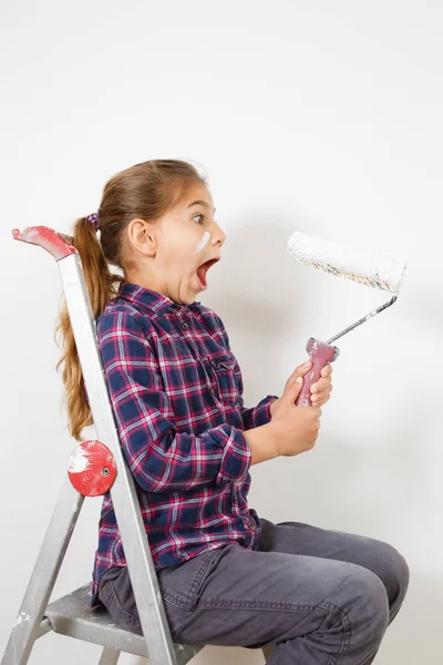 Teen girl on building ladder shocked with brush for painting on — Stock Photo, Image