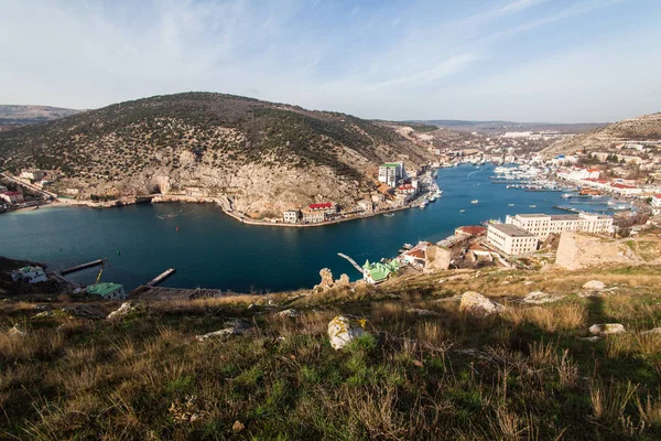 Gyönyörű kilátás nyílik a Fekete-tenger és a város Balaklava. Balaklava Bay. Világos napsütéses napon, és egy felülnézet, a port, Crimea — Stock Fotó