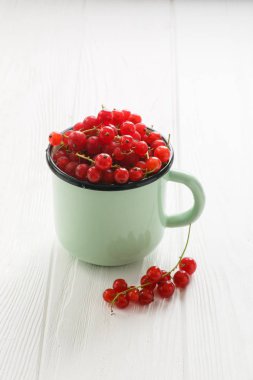 Bir beyaz tahta tabloda çay Kupası'nda kırmızı kuş üzümü