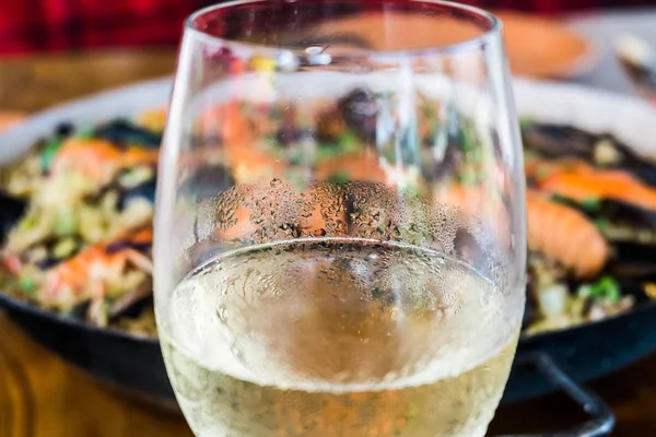 Seafood Paella with mussels and crayfish and glass of white wine — Stock Photo, Image