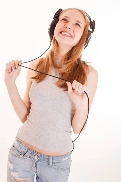 Girl in headphones listens to music — Stock Photo, Image