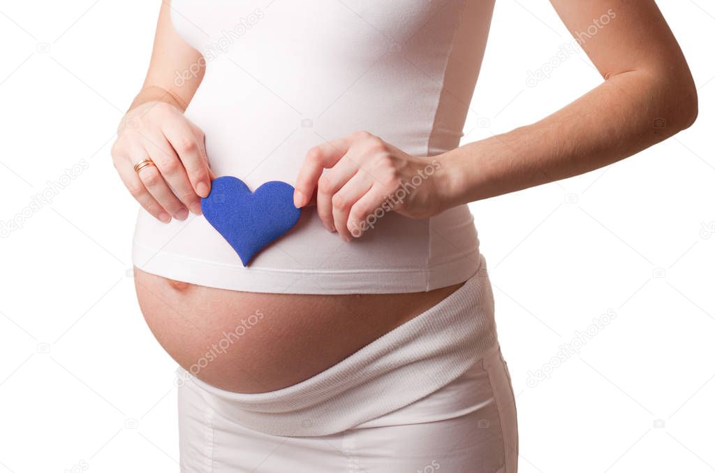 pregnant woman put a blue toy heart to his stomach isolated on white
