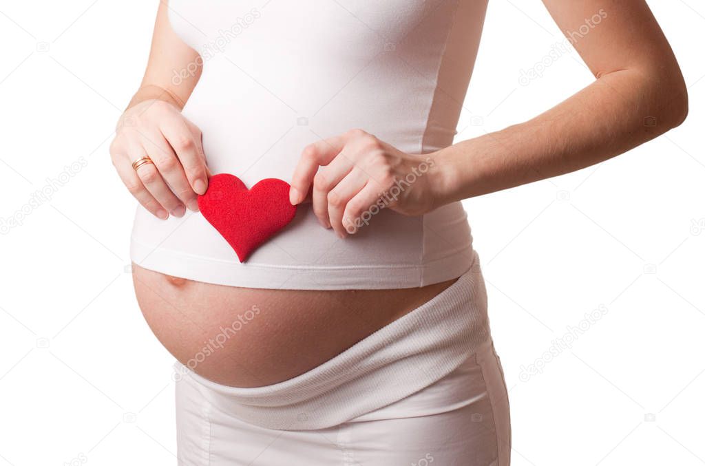 pregnant woman put a red toy heart to his stomach isolated on white