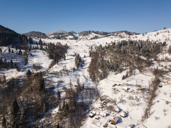 Calma y acogedor pueblo de cuento de hadas Kryvorivnia cubierto de nieve en las montañas Cárpatos, vista aérea. Paisaje típico en el Parque Nacional Hutsulshchyna en Ucrania. Vacaciones y deportes de invierno . —  Fotos de Stock