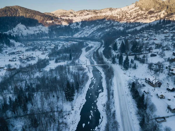 Calma y acogedor pueblo de cuento de hadas Kryvorivnia cubierto de nieve en las montañas Cárpatos, vista aérea. Paisaje típico en el Parque Nacional Hutsulshchyna en Ucrania. Vacaciones y deportes de invierno . —  Fotos de Stock