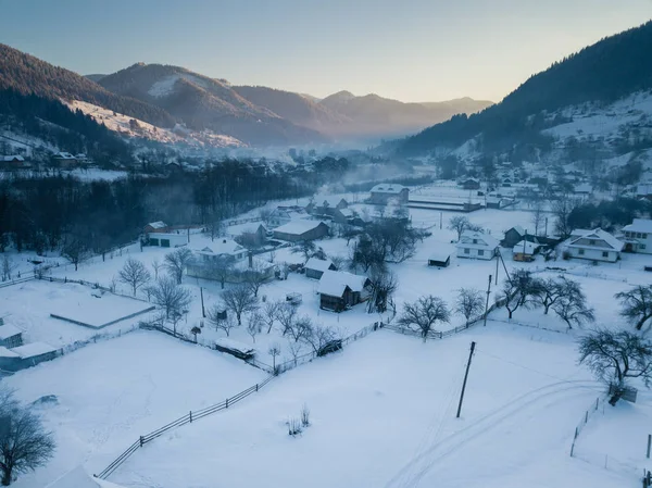 Klidná a útulná pohádková vesnice Kryvorivnia pokrytá sněhem v Karpatech, letecký výhled. Typická krajina v národním parku Hutsulshchyna na Ukrajině. Dovolená a zimní sporty. Royalty Free Stock Fotografie